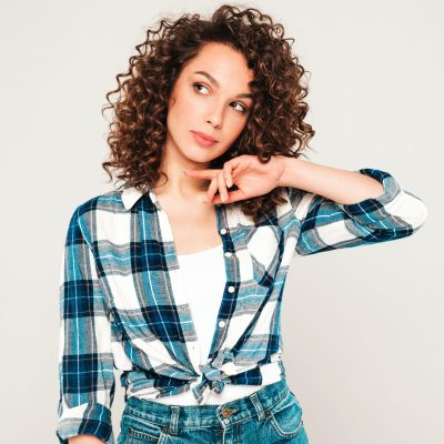 Portrait of beautiful smiling model with afro curls hairstyle dressed in summer hipster clothes.Sexy carefree girl posing in studio on gray background.Trendy funny and positive woman Portrait of beautiful smiling model with afro curls hairstyle dressed in summer hipster clothes.Sexy carefree girl posing in studio on gray background.Trendy funny and positive woman